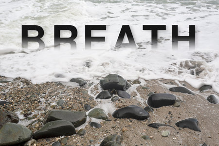 Word BREATH on a pebble beach with wave and foamの写真素材