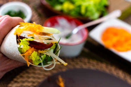 man holding typical Mexican fajita with shrimp and vegetablesの写真素材