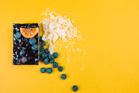 gourmet cheesecake with red berries blueberries strawberry and orange on a yellow background