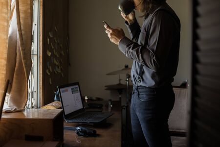 man with long hair and glasses working from home on financial issuesの写真素材