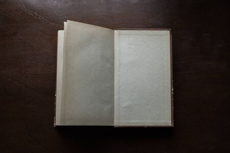 an old book with blank pages on wooden desk
