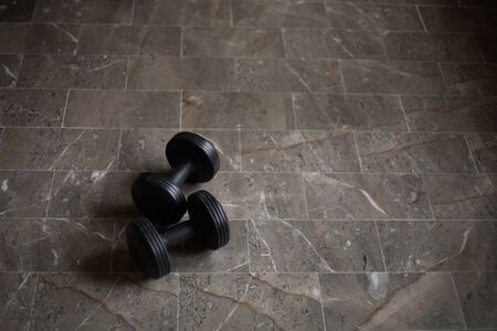 A guy exercising at home with dumbbells, stretching, shoulder exercises and boxing warm-upの写真素材