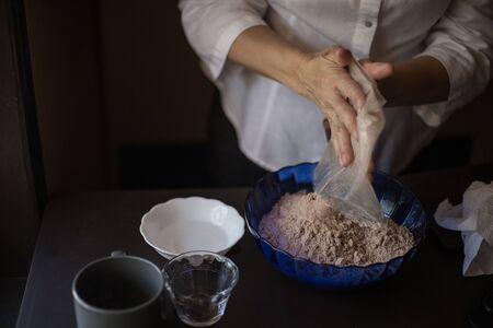 housewife preparing brownies on a dark wooden tableの写真素材