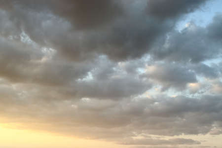 Storm clouds, cloudy sky before raining, dark toned sky and sunlightの写真素材