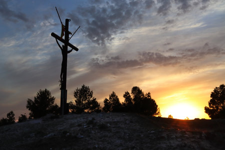 Cross on the mountain at sunsetの写真素材