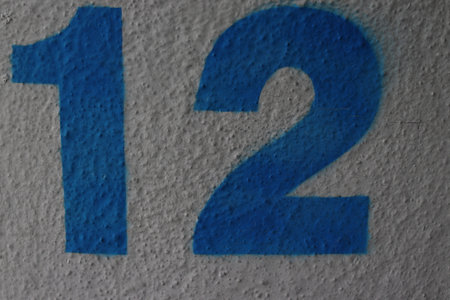 Number twelve painted in blue on a wallの写真素材