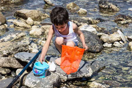 A boy plays on the sea rocks in Sestri Levanteのeditorial素材