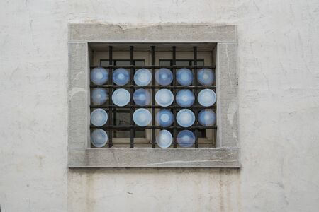 small colorful dishes decorated in a window of a house in the historic center of Venzone, Friuli, Italyの写真素材