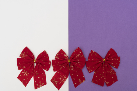 red Christmas bows on a colored backgroundの写真素材