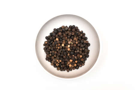 black pepper in a bowl on a colored background