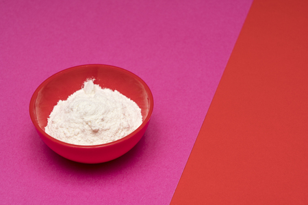 flour in a bowl on a colored backgroundの写真素材