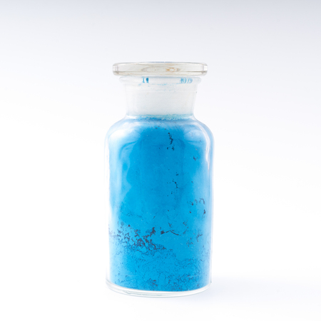 glass flask containing natural blue colored pigment powderの写真素材