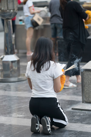 Some faithful pray in Trimurti Shrine (God of Love) street temple in Ratchadamri Road, Bangkok, Thailandのeditorial素材