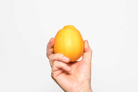an orange held in one handの写真素材