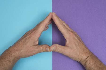 the hands of a man placed side by side on a two-color surface