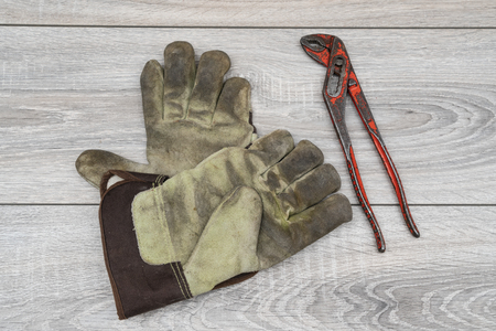 a parrot key and a pair of work gloves on a wooden table