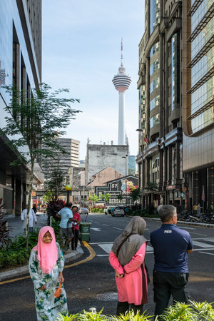 People on the streets with the Menara tower in the background in Kuala Lumpur, Malaysiaのeditorial素材