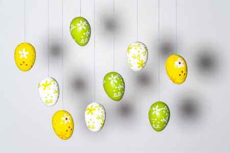 some colorful and decorated Easter eggs hanging by a threadの写真素材