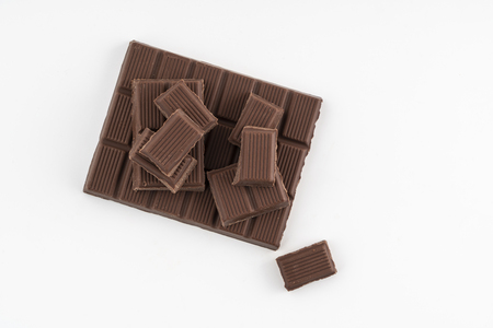 a chocolate bar chopped on a white surfaceの写真素材