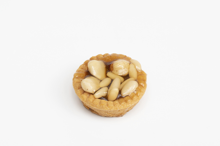a round pastry with nuts on a white tableの写真素材