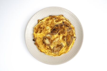 an omelette with potatoes on the plateの写真素材