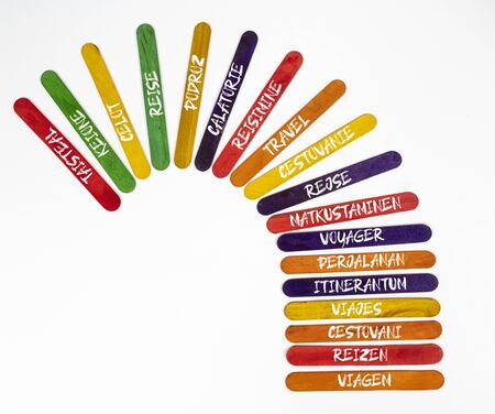 the concept of the word travel in various languages written on colored wooden slats