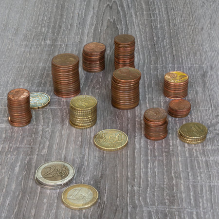Udine, Italy, July 17, 2019.  some stacks of euro coins on a wooden tableのeditorial素材