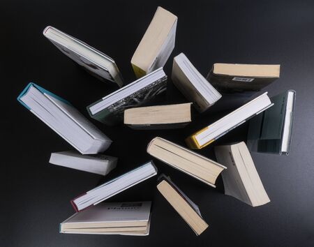 a series of books on a black surface seen from above