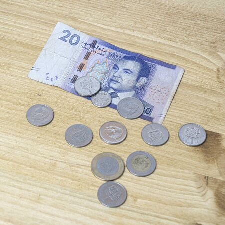 A 20 Dirham banknote of Morocco with some coins on the table