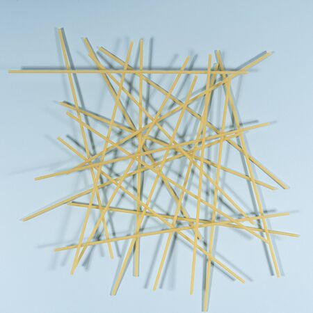 intertwining spaghetti pasta on a colored surfaceの写真素材