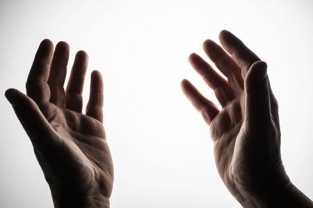 two hands open on a backlit surface