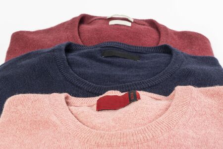 three colored wool shirtson a white table