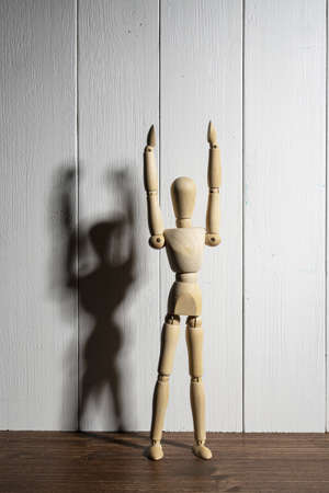 the joy on the face of a wooden mannequin with raised armsの写真素材