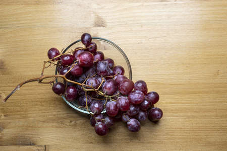 a bunch of pink grapes on a wooden table