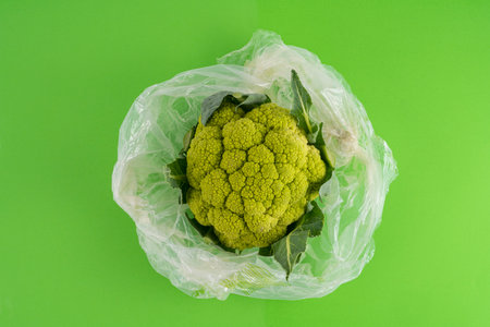 a green cauliflower in a bag on a green surface