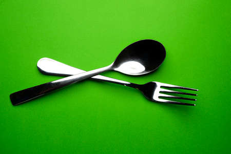 two forks with some types of colored pasta on a yellow surfaceの写真素材