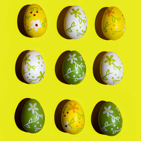 Some decorated Easter eggs on a yellow surface