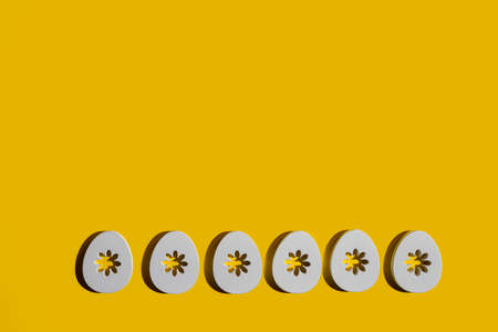 Some decorated wooden Easter eggs on a yellow surface