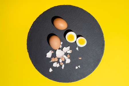 Some hard-boiled eggs on a black stone plateの写真素材