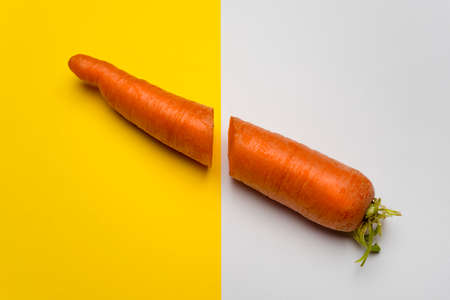 the carrot cut in half on a colored surfaceの写真素材