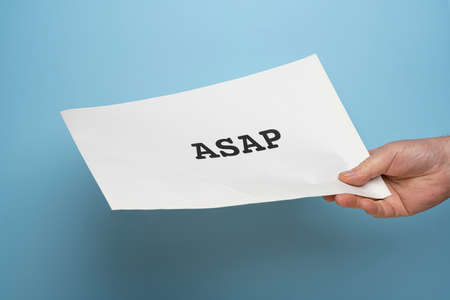 a man handing out an envelope with the message As Soon As Possible