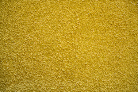 the plaster of a yellow wall as a backgroundの写真素材