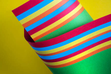 Some colored sticks on a yellow surface as the gay pride symbol
