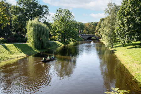 Riga, Latvia. 22 August 2021. A boat for the transport of tourists in the river that crosses a park in the city centerのeditorial素材