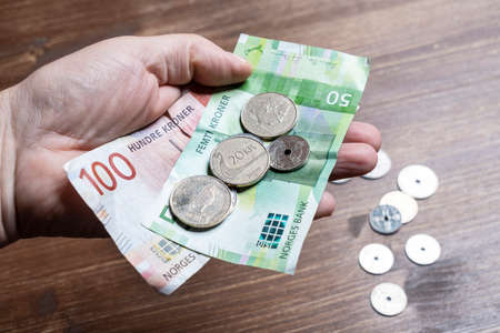 Oslo, Norway. September 2021. some Norwegian forint bills and coins in the handの写真素材