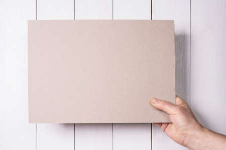 a cardboard sign held in hand