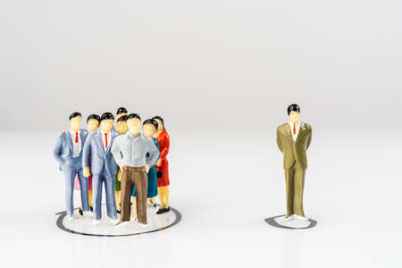 A group and a single miniature models isolated within a circle drawn on a surfaceの写真素材