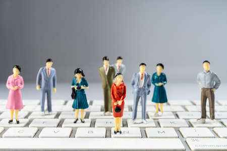 some miniature models on a computer keyboardの写真素材
