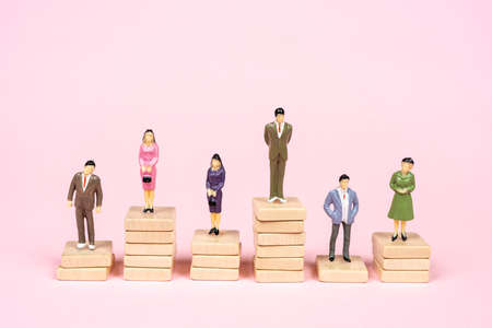 some miniature model people on top of some piles of wooden dowelsの写真素材