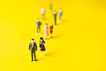 some figurines of men and women on a yellow surface.